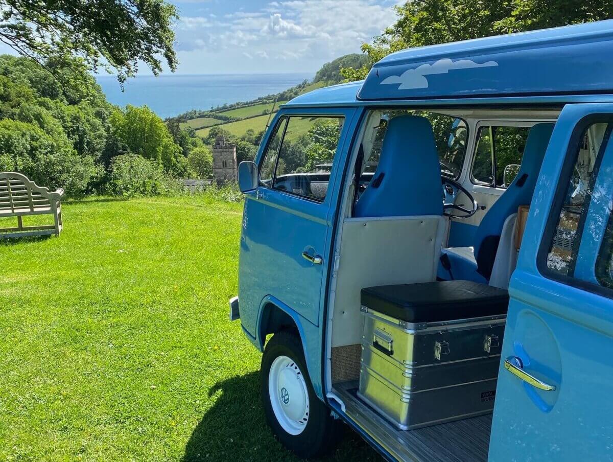 blue campervan with sea view